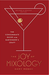 The Joy of Mixology Revised and Updated: The Consummate Guide to the Bartender's Craft' book cover featuring a martini glass, shaker, and various cocktail ingredients